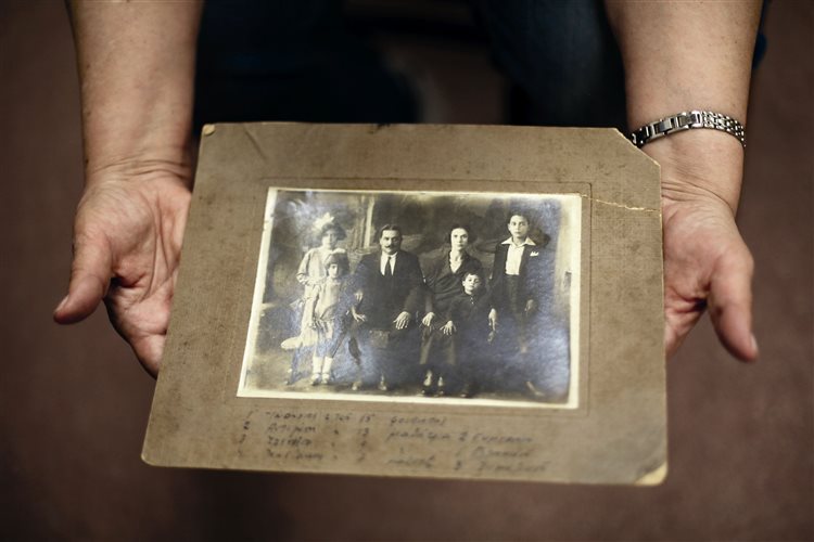 Η Μάγκυ Σπυροπούλου κρατάει μια φωτογραφία από το ιστορικό φωτογραφικό αρχείο της Ελληνορθόδοξης Εκκλησίας