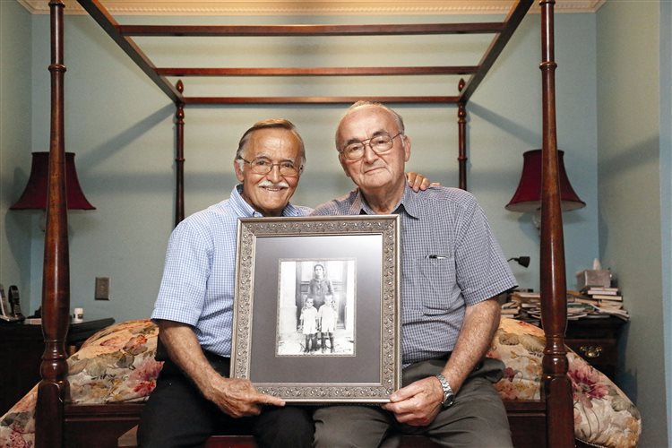Ο Μιχάλης Χριστάκης (αριστερά) με τον αδελφό του Λεωνίδα κρατώντας μια φωτογραφία από τα παιδικά τους χρόνια στη Χίο. Σκόπευαν να μείνουν για λίγο στις ΗΠΑ. Είναι εκεί ήδη 50 χρόνια